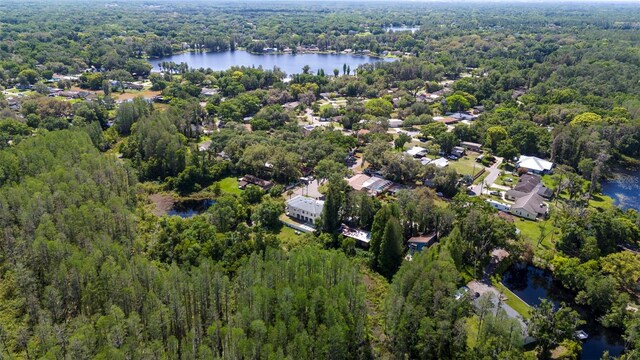 birds eye view of property with a water view and a wooded view