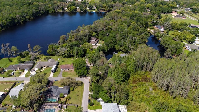 drone / aerial view featuring a residential view, a wooded view, and a water view