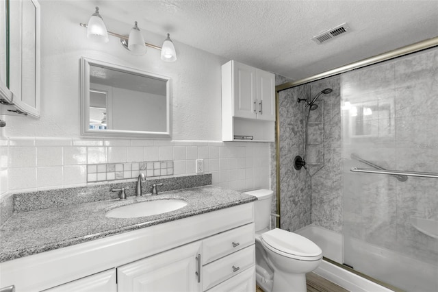 full bathroom with visible vents, a textured ceiling, tile walls, and a shower stall