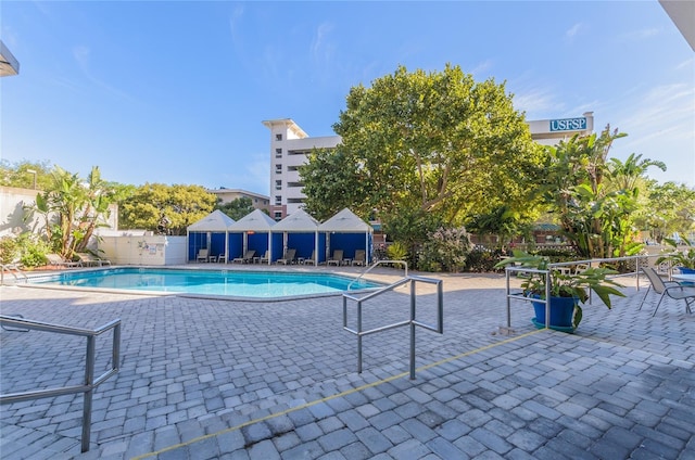 pool with a patio and fence