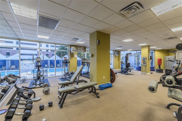 gym featuring floor to ceiling windows, carpet, and visible vents