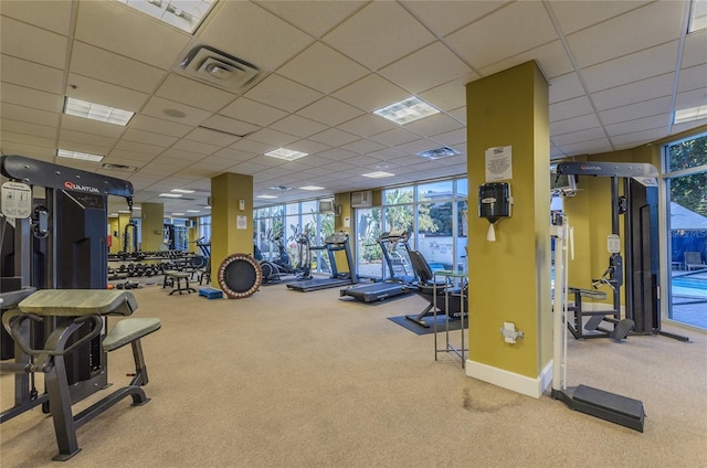 exercise room featuring carpet flooring, baseboards, visible vents, and a paneled ceiling