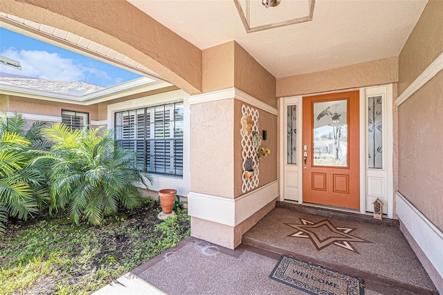 doorway to property featuring stucco siding