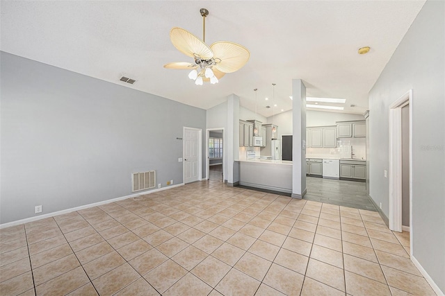 unfurnished living room with vaulted ceiling, a ceiling fan, visible vents, and a sink