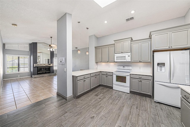 kitchen with white appliances, a ceiling fan, gray cabinets, and light countertops