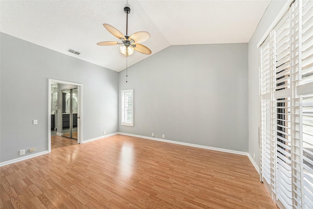 unfurnished bedroom featuring light wood finished floors, visible vents, baseboards, and vaulted ceiling