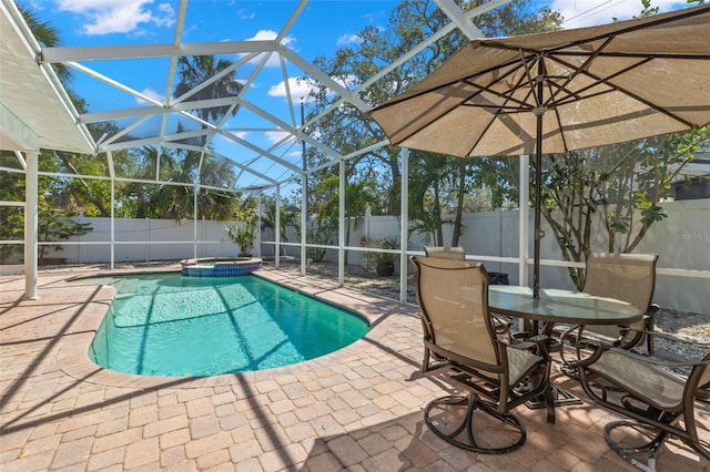 view of swimming pool with glass enclosure, a patio area, and a fenced backyard