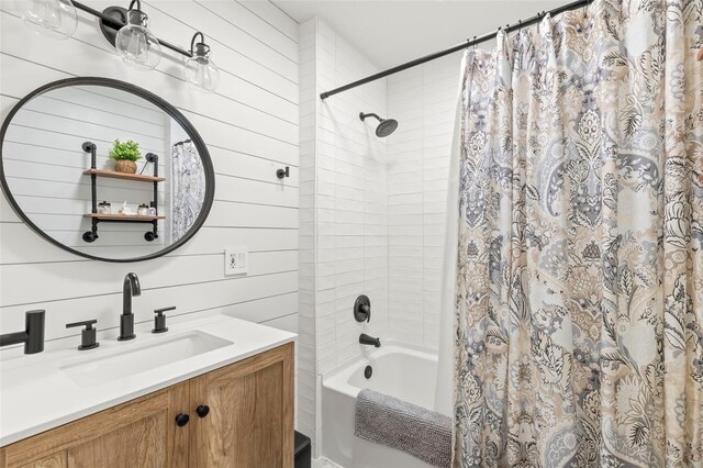 full bathroom with wooden walls, vanity, and shower / bath combination with curtain