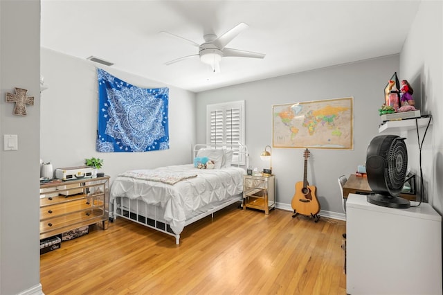 bedroom featuring light wood-type flooring, visible vents, baseboards, and ceiling fan