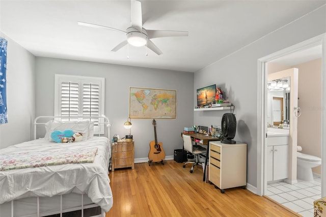 bedroom featuring light wood-type flooring, baseboards, and connected bathroom