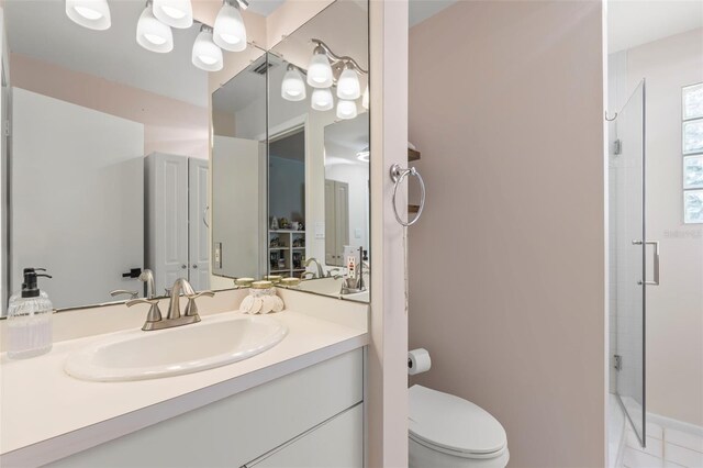 bathroom with a shower stall, toilet, and vanity