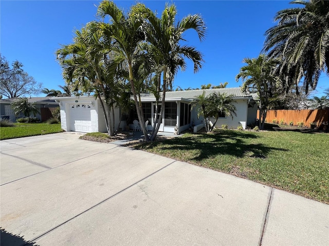 ranch-style house with fence, driveway, stucco siding, a front lawn, and a garage