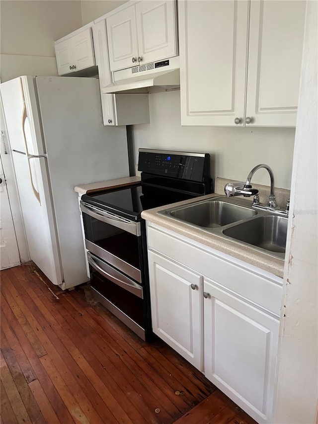 kitchen with dark wood-type flooring, under cabinet range hood, double oven range, white cabinetry, and a sink