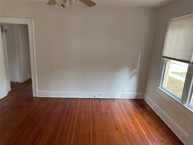 spare room featuring hardwood / wood-style floors, baseboards, and ceiling fan