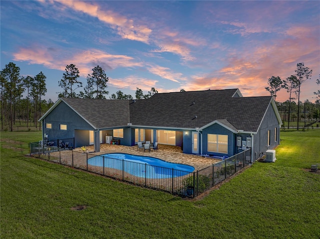 pool at dusk with a patio, a yard, fence, and central AC