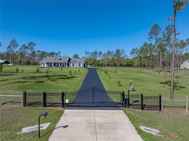 exterior space with a front lawn, a gate, and fence