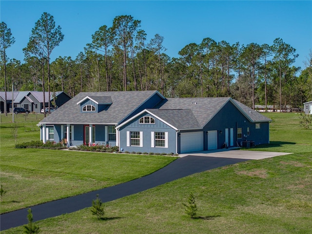 view of front of property with a front yard, driveway, an attached garage, a shingled roof, and central air condition unit