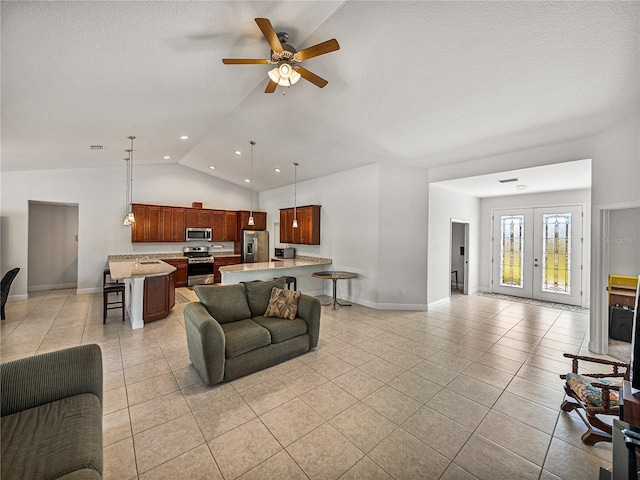 living area with ceiling fan, vaulted ceiling, light tile patterned floors, french doors, and a textured ceiling