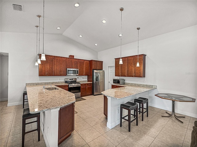 kitchen with a kitchen bar, visible vents, a sink, appliances with stainless steel finishes, and a peninsula