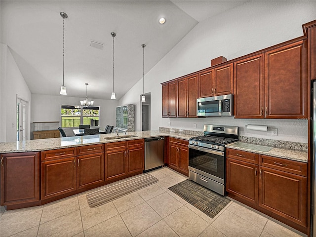 kitchen featuring light stone counters, visible vents, a peninsula, a sink, and stainless steel appliances