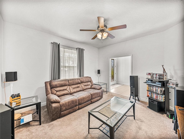 living room featuring light colored carpet, baseboards, and ceiling fan