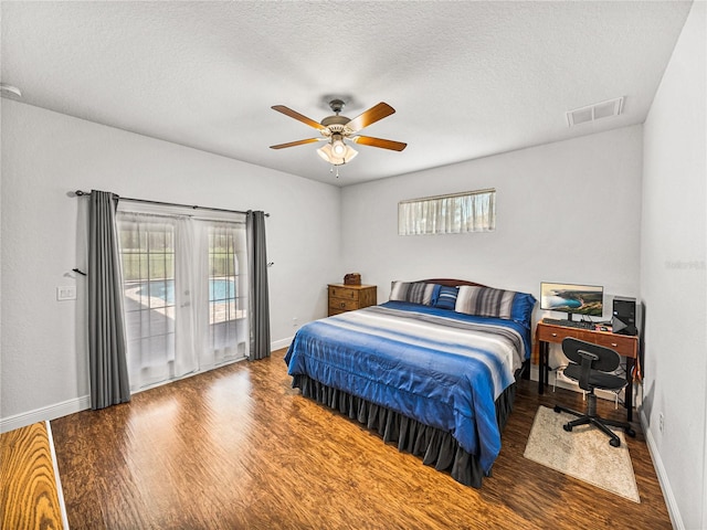 bedroom with a textured ceiling, wood finished floors, a ceiling fan, and access to exterior