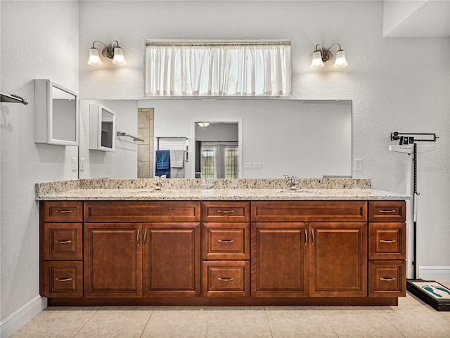 full bathroom with a sink, baseboards, walk in shower, and double vanity