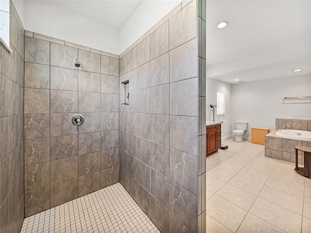 bathroom featuring vanity, tile patterned floors, a bath, and a tile shower