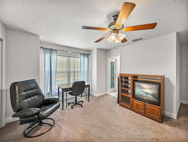 office area featuring baseboards, visible vents, a ceiling fan, and carpet