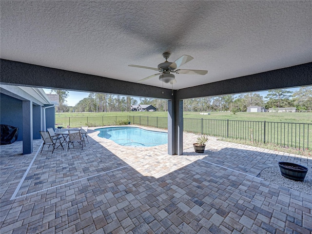 view of swimming pool with a lawn, a patio, a ceiling fan, and a fenced backyard