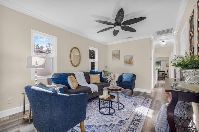 living area with visible vents, crown molding, ceiling fan, and wood finished floors