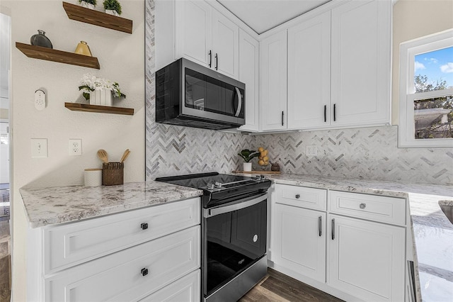 kitchen with light stone countertops, open shelves, white cabinets, appliances with stainless steel finishes, and backsplash