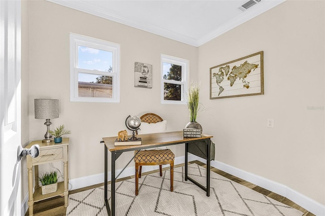 office area with visible vents, light wood-style flooring, baseboards, and ornamental molding