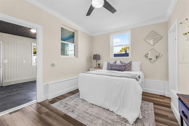 bedroom with crown molding, multiple windows, and wood finished floors