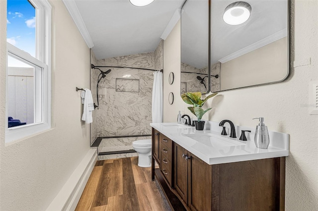 bathroom with a sink, toilet, wood finished floors, and crown molding