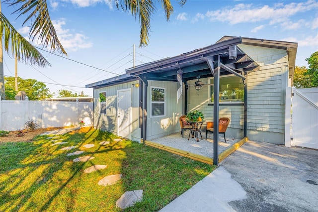 rear view of property featuring a yard, a patio, and a fenced backyard