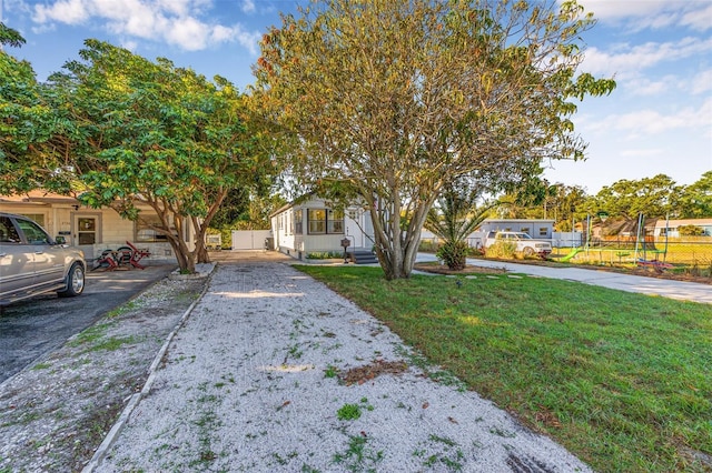 obstructed view of property with a front lawn and fence