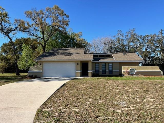 view of front of property with stucco siding, driveway, and an attached garage