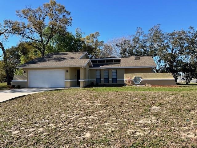 view of front of property featuring stucco siding, driveway, and a garage