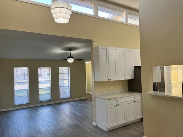 kitchen featuring dark wood-style floors, light countertops, white cabinets, and a healthy amount of sunlight