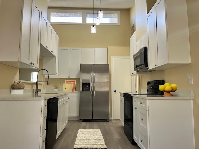 kitchen featuring white cabinetry, black appliances, and a sink