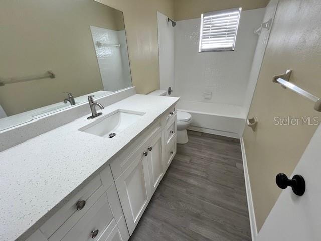 bathroom with bathing tub / shower combination, toilet, wood finished floors, and vanity