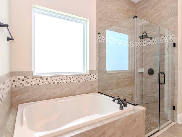 bathroom featuring a stall shower and a garden tub