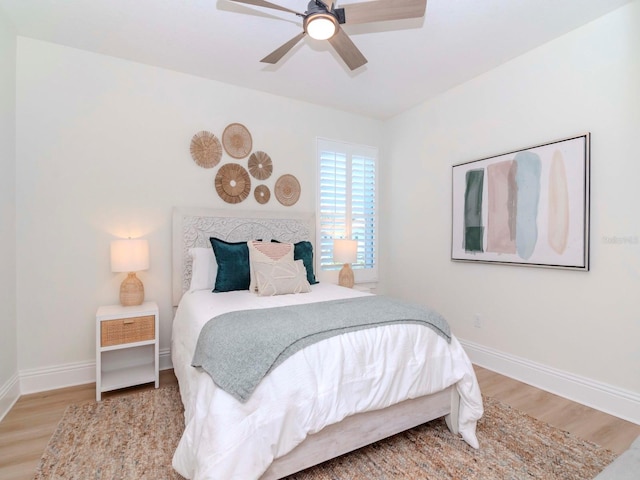 bedroom with ceiling fan, baseboards, and wood finished floors