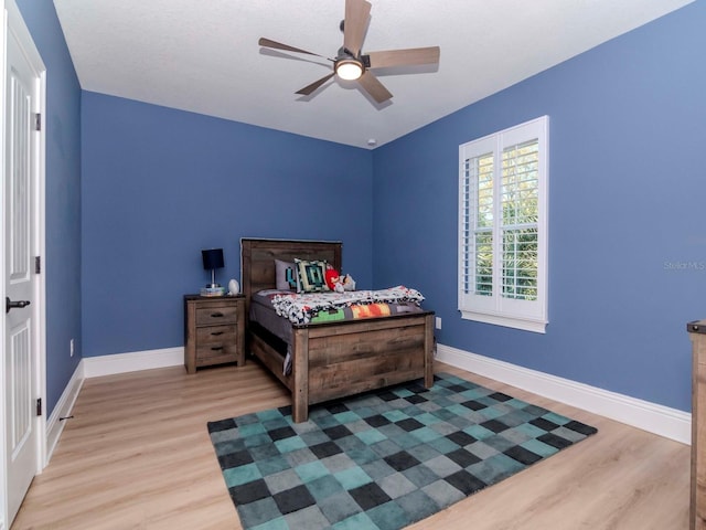 bedroom featuring ceiling fan, baseboards, and wood finished floors