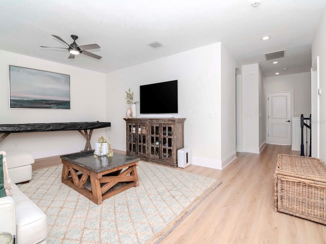 living area featuring visible vents, a ceiling fan, baseboards, and wood finished floors