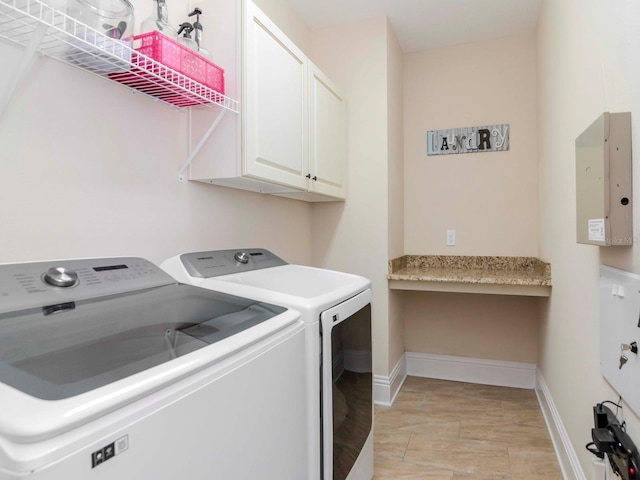 laundry area featuring cabinet space, washer and dryer, and baseboards