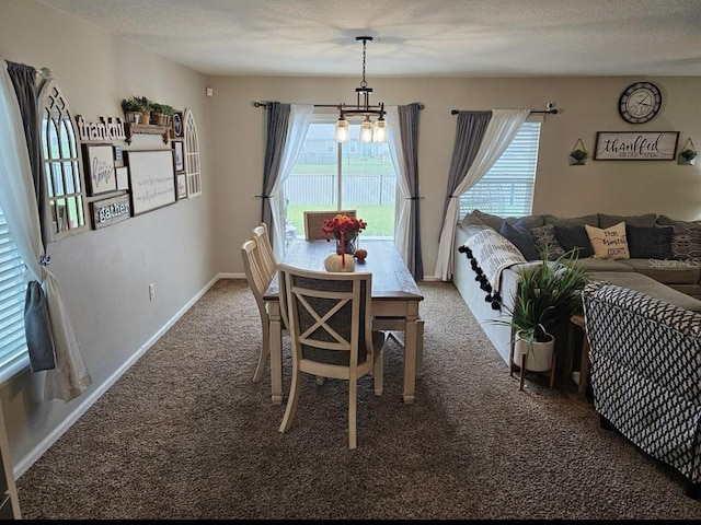 carpeted dining space featuring a textured ceiling and baseboards