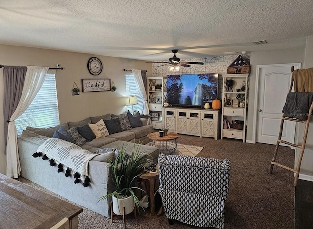 carpeted living area featuring plenty of natural light, a ceiling fan, visible vents, and a textured ceiling