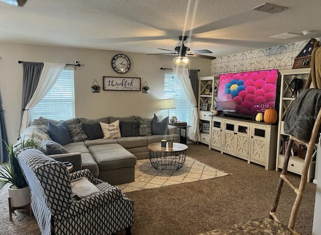 carpeted living room featuring wallpapered walls, a ceiling fan, and a textured ceiling